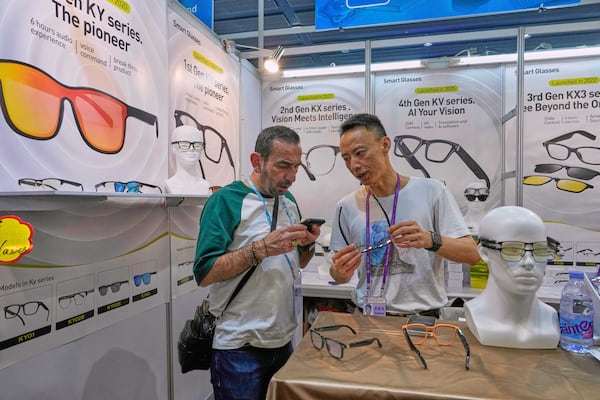 A visitor looks at China made smart glasses promoted at the 137th Canton Fair in Guangzhou in southern China's Guangdong province on Tuesday, April 15, 2025. (AP Photo/Ng Han Guan)