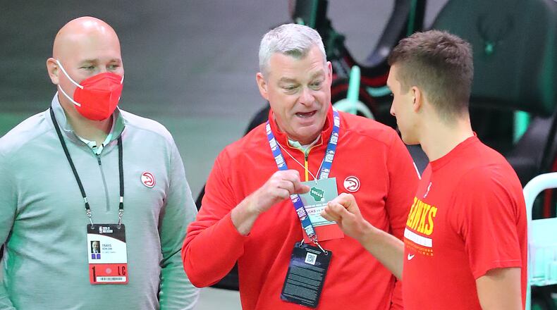 Atlanta Hawks guard Bogan Bogdanovic gives owner Tony Ressler a fist bump with general manager & president Travis Schlenk looking on as he takes the court for warm ups before playing the Milwaukee Bucks in Game 2 of the NBA Eastern Conference Finals on Friday, June 25, 2021, in Milwaukee.  Curtis Compton / Curtis.Compton@ajc.com