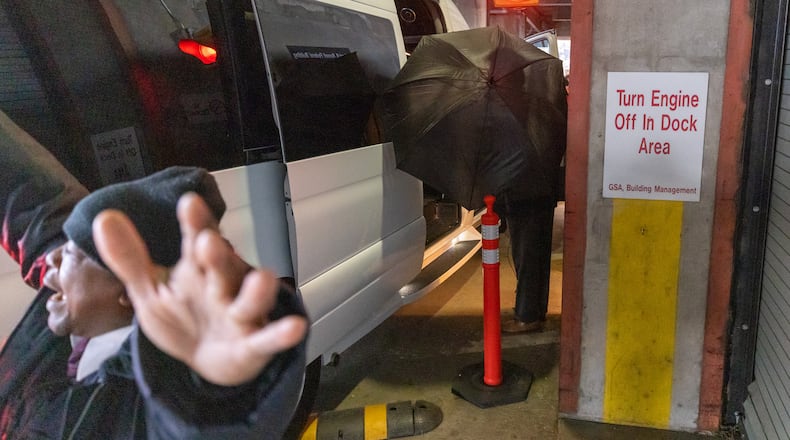 A security guard tries to block the view of ex-Clayton County Sheriff Victor Hill as he enters the Richard B. Russell Federal building for his prison sentence hearing Tuesday. (Steve Schaefer/steve.schaefer@ajc.com)