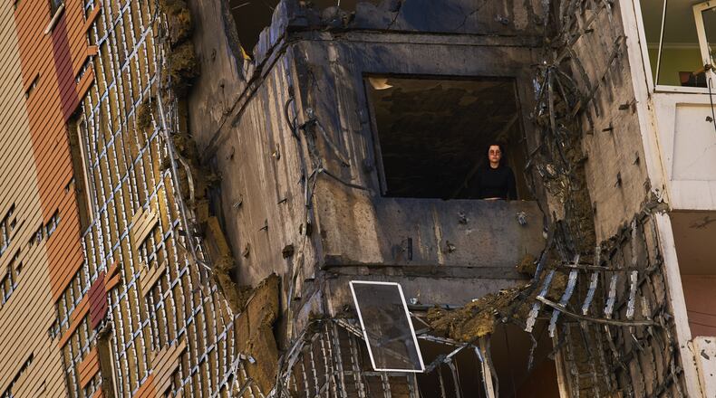 A woman peers from a window of a partially damaged residential building following a Russian drone attack in Kyiv, Ukraine, Wednesday, Sept. 9, 2026. (AP Photo/Francisco Seco)