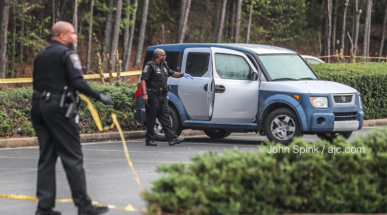 DeKalb County police investigate a fatal shooting Wednesday morning in the parking lot of the Salem Crossing plaza on Panola Road.