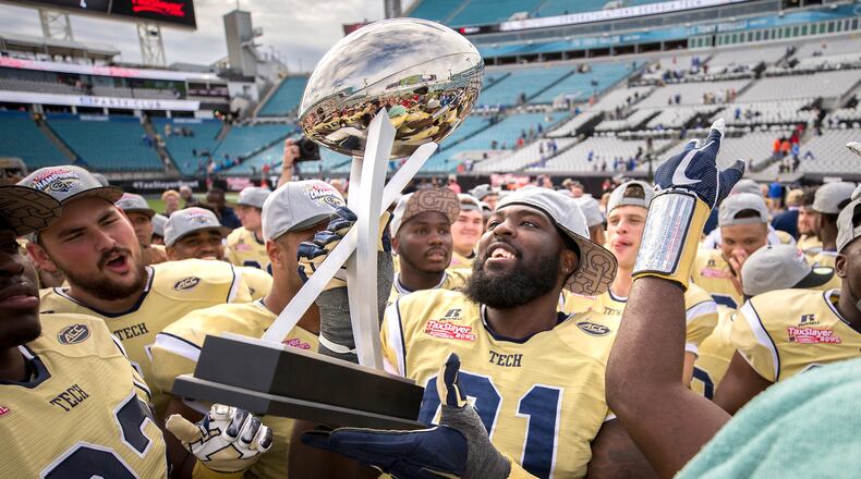 Georgia Tech defensive lineman Patrick Gamble (91) and his teammates celebrate with the trophy after the TaxSlayer Bowl NCAA college football game against Kentucky, Saturday, Dec. 31, 2016, in Jacksonville, Fla. Georgia Tech beat Kentucky 33-18. (AP Photo/Stephen B. Morton)