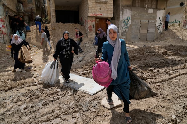 Residents of the now evacuated refugee camp of Tulkarem return to collect belongings before the destruction of their homes as Israeli forces prepare to carry out the demolition of 116 homes across the two refugee camps of the Israeli occupied West Bank city of Tulkarem, Friday, May 2, 2025. (AP Photo/Nasser Nasser)