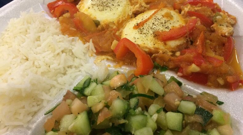 Shakshuka (poached eggs in a sauce of tomatoes, peppers and onions) with rice and salad at kosher restaurant Pita Grille. LIGAYA FIGUERAS / LFIGUERAS@AJC.COM