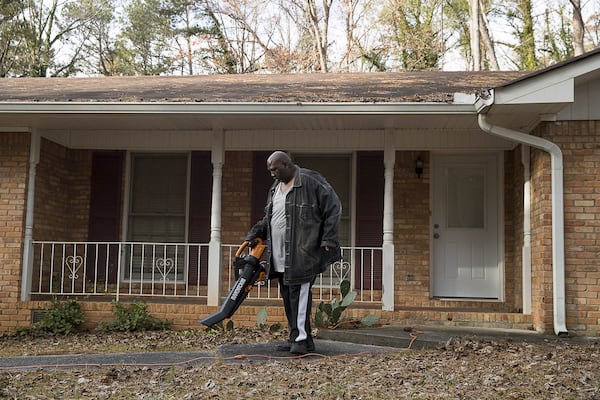 Jerard Morton blows leaves in his front yard at the Loch Lomond Estates neighborhood subdivision in South Fulton. (ALYSSA POINTER/ALYSSA.POINTER@AJC.COM)