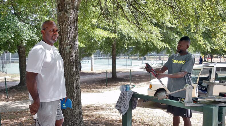 Darrell Hooker (left), prepares for a tennis lesson with Scott Ross at Trammell Crow Park. “I want to know how they are going to enforce it” Ross said of the smoking ban. Fulton County has approved a smoking ban in county parks. Smokers will get $1,000 fine or jail time. BOB ANDRES /BANDRES@AJC.COM