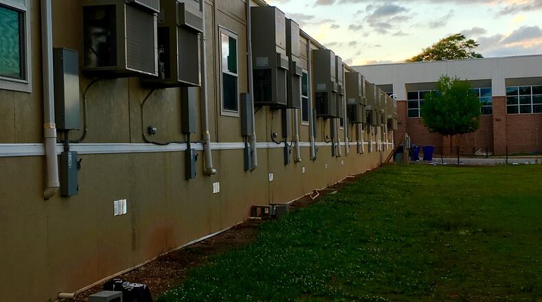 These modular units at Renfroe Middle School will all disappear this summer, thus restoring most of the green space behind the school. There are 12 total with Renfroe’s gym shown here in the background. Bill Banks for the AJC