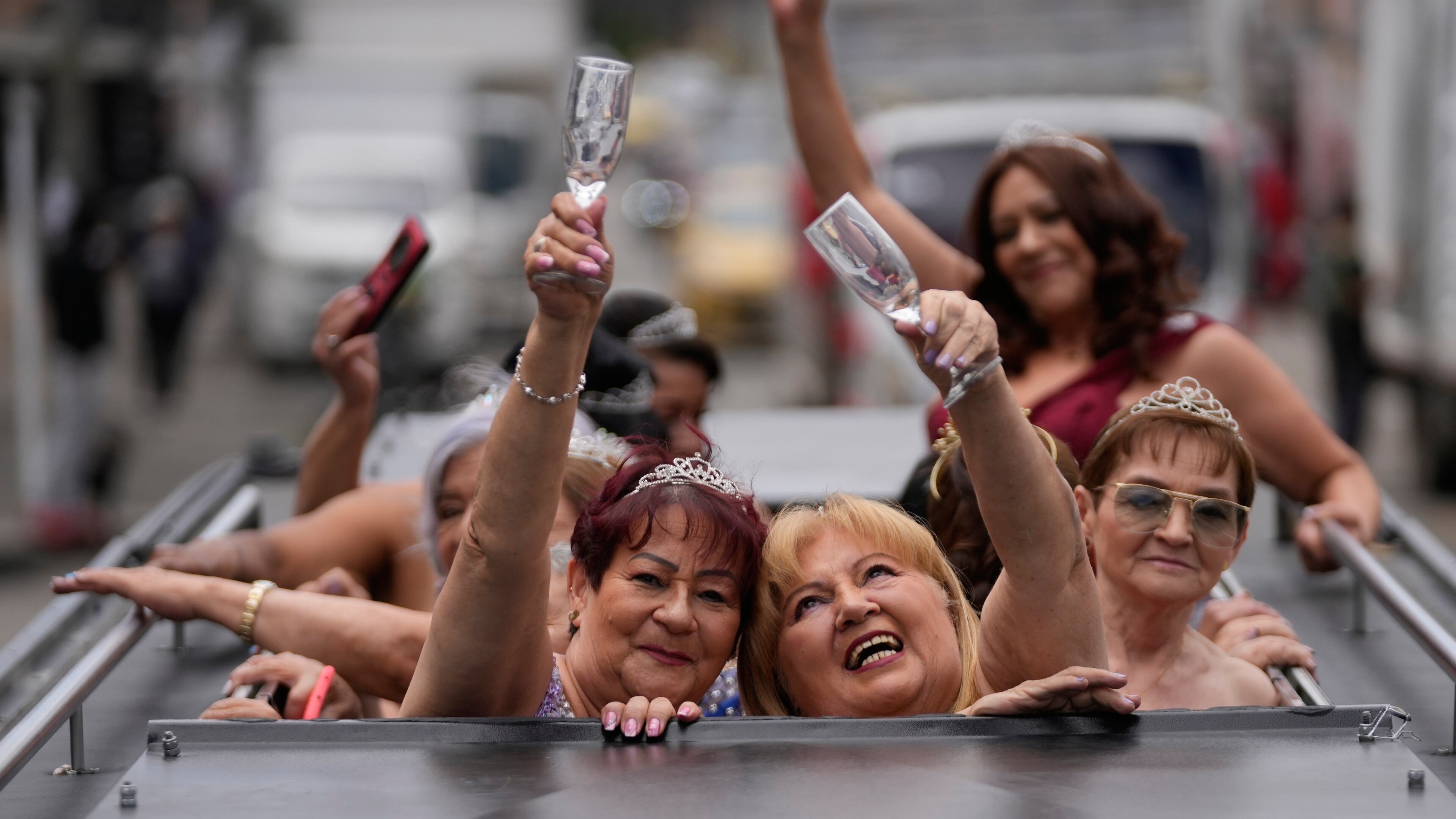 Blanca Guerrero, 67, left, and Gloria Sanabria, 67, right, ride in a limousine to a quinceanera celebration for women who never had a traditional 15th birthday party, organized by the Suenos Hechos foundation in Bogota, Colombia, Friday, Oct. 24, 2025.(AP Photo/Fernando Vergara)