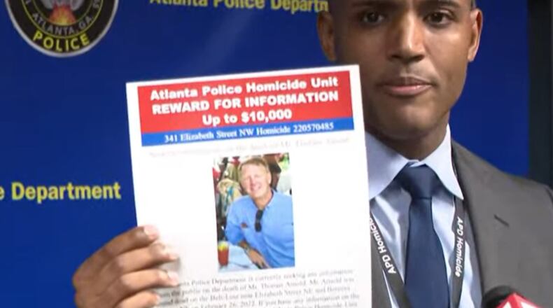 Lt. Ralph Woolfolk, commander of Atlanta police's homicide unit, holds up a photo showing the reward for information in Thomas Arnold's homicide investigation during a news conference Wednesday night.