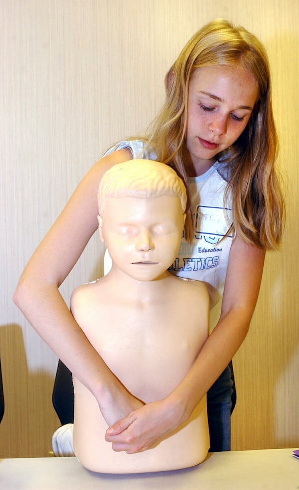 FILE - Alainna Lantz, 12, of Bridgeport, W.Va., practices the Heimlich maneuver during a free Safe Sitter course offered by West Virginia University's Center for Rural Emergency Medicine on June 11, 2003, in Fairmont, W.Va. (AP Photo/Dale Sparks, File)