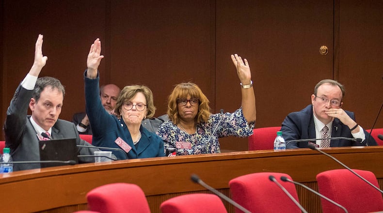 Republican state Rep. Scot Turner of Holly Springs, right, keeps his hand down Monday as Democratic committee colleagues Bob Trammell of Luthersville, Mary Frances Williams of Marietta, second from left, and Rhonda Burnough of Riverdale, vote in favor of a substitute to House Bill 757 during a subcommittee meeting of the House Governmental Affairs Committee at the Paul D. Coverdell Legislative Office Building in Atlanta. The substitute, backing creation of a partisan primary for this year’s U.S. Senate special election, passed on an 8-2 vote. Turner and state Rep. Barry Fleming, R-Harlem, voted against the substitute. (ALYSSA POINTER/ALYSSA.POINTER@AJC.COM)