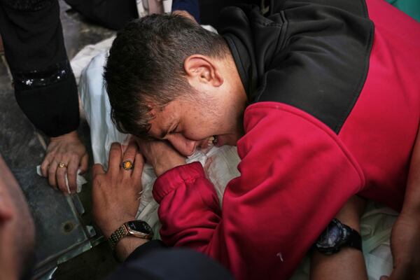 A relative mourn over the body of Abdullah Habbash before his funeral, along with six brothers from the Abu Mahadi family, all members of a Palestinian charity organization linked to Hamas, who were killed earlier in an Israeli army strike on the car they were traveling in, in Deir al-Balah, central Gaza Strip, Sunday, April 13, 2025. (AP Photo/Abdel Kareem Hana)"