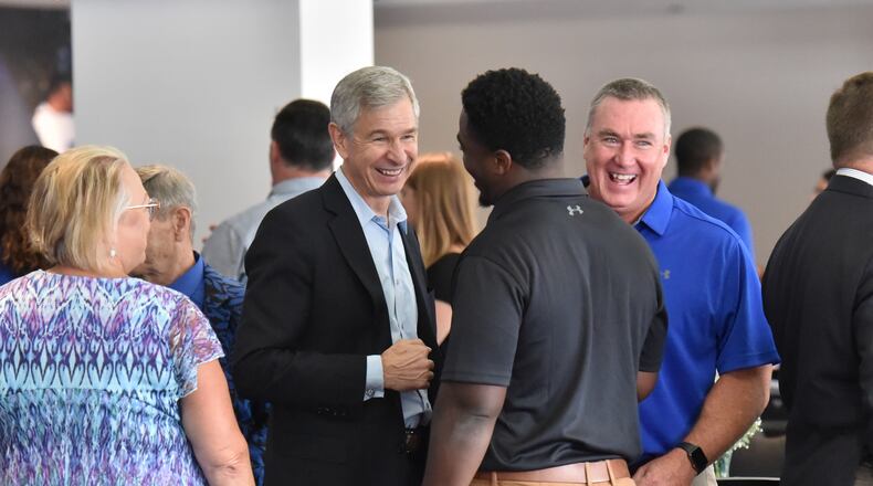 Georgia State University President Mark Becker (center left) and GSU football head coach Shawn Elliott (center right), react as they talk to linebacker Ed Curney (center) during 2019 Football Kickoff Luncheon at Georgia State Stadium on Wednesday, August 14, 2019. When Mark Becker was hired as Georgia State University's president a decade ago, the school was largely considered a commuter campus and a place for adult workers to get their degrees. Today, Georgia State has the largest enrollment of any college, public or private, in the state and has the reputation as one of the best schools in the nation for non-white students to earn their degrees by using data to determine where students need assistance.