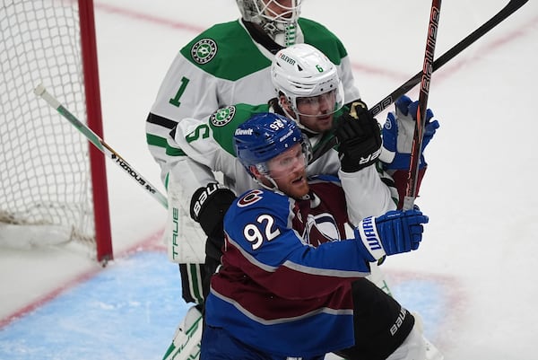 Colorado Avalanche left wing Gabriel Landeskog, front, jostles for position in front of the net with Dallas Stars defenseman Lian Bichsel in the third period of Game 4 of an NHL hockey first-round playoff series Saturday, April 26, 2025, in Denver. (AP Photo/David Zalubowski)
