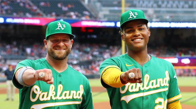 Former Atlanta Braves Stephen Vogt (left) and Cristian Pache, now with the Oakland Athletics, are presented their World Series rings before playing the Braves on Tuesday in Atlanta. (Curtis Compton / Curtis.Compton@ajc.com)