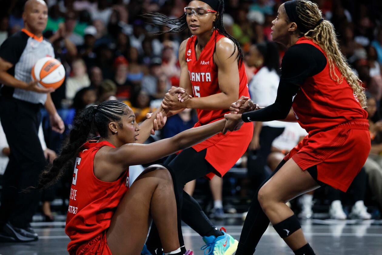 Dream guards Allisha Gray (center) and Jordin Canada help forward Angel Reese up during their game against the Minnesota Lynx at Gateway Center Arena on Sunday, Aug. 30, 2026, in Atlanta. Reese says she and her team are “going to go all the way.” (Miguel Martinez/AJC)