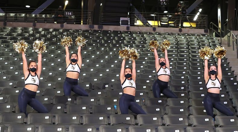 Georgia Tech cheerleaders mask up in mostly empty stands during the season opener against Georgia State in a NCAA college basketball game in Atlanta on Wednesday, Nov 25, 2020, in Atlanta. Georgia's public university system is encouraging, but not requiring staff and students to wear masks. (Curtis Compton / Curtis.Compton@ajc.com)