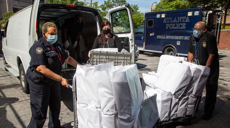 Kim Jones (left), Kelsey Hull and Bruce Ford help Avalon Catering deliver 600 meals at Atlanta Public Safety headquarters in downtown Atlanta as part of Feed the Frontline. Atlanta police, detectives and other APD personnel got a free lunch as appreciation for their hard work. PHIL SKINNER FOR THE ATLANTA JOURNAL-CONSTITUTION.