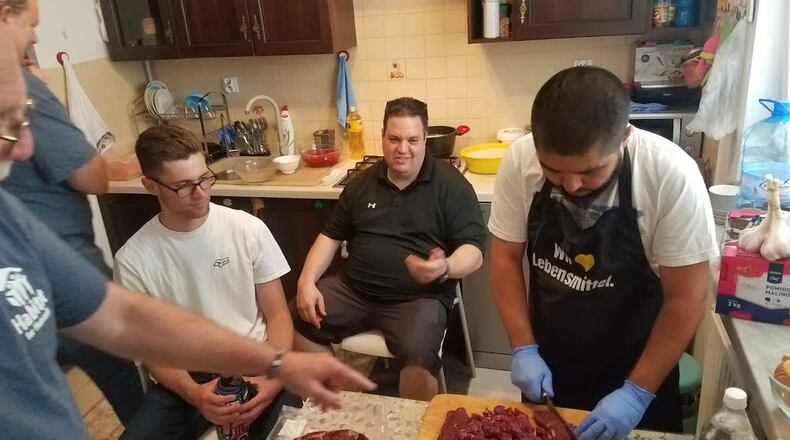One Saturday afternoon, the 14 Americans who had traveled to Poland as part of a Habitat for Humanity trip met a family in Warsaw to enjoy a home-cooked meal. Bekzhod Mamadzanov (right) showed the group, including Jake Wilkoff (center) and Cameron Wolf (left), how to prepare a dinner that is popular in Kyrgyzstan. CONTRIBUTED BY MARGARET WILKOFF