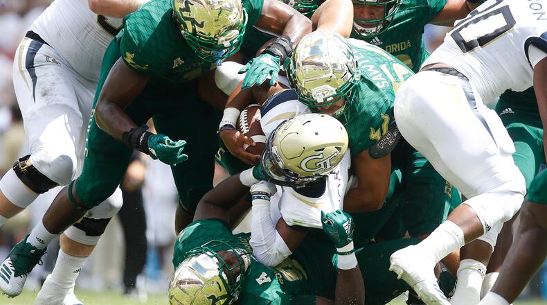 Georgia Tech quarterback TaQuon Marshall (16) runs the ball while tackled by South Florida linebacker Nico Sawtelle (54) and a host of other Bulls during the first half at Raymond James Stadium in Tampa, Fla., on Saturday, Sept. 8, 2018. South Florida won, 49-38. (Octavio Jones/Tampa Bay Times/TNS)