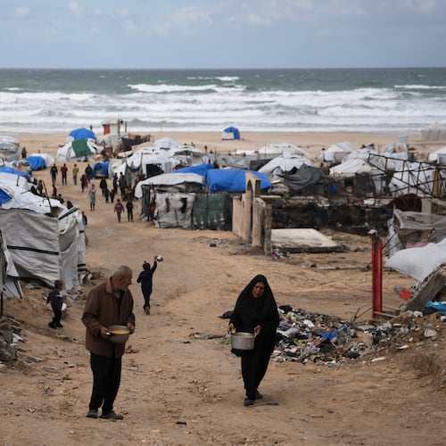 Palestinians receive donated food at a temporary camp for displaced people, on the beach near the port of Gaza City, Sunday, Dec. 28, 2025. (AP Photo/Jehad Alshrafi)