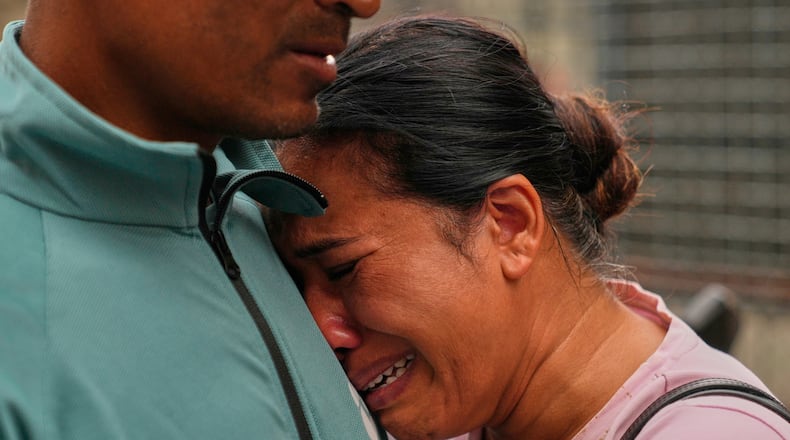A relative consoles Sabina Dangal outside a government hospital as she waits for news of her brother, who is missing after flash floods, in Kathmandu, Nepal, Friday, Aug. 28, 2026. (AP Photo/Dar Yasin)
