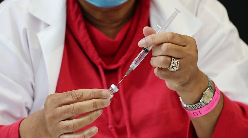 A nurse prepares a Pfizer vaccine earlier this year at an Atlanta vaccination site. “Curtis Compton / Curtis.Compton@ajc.com”