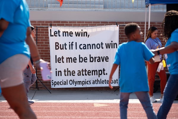 Atlanta Public Schools students walk past the Special Olympics oath at Lakewood Stadium on Wednesday, (Ben Gray for the AJC)