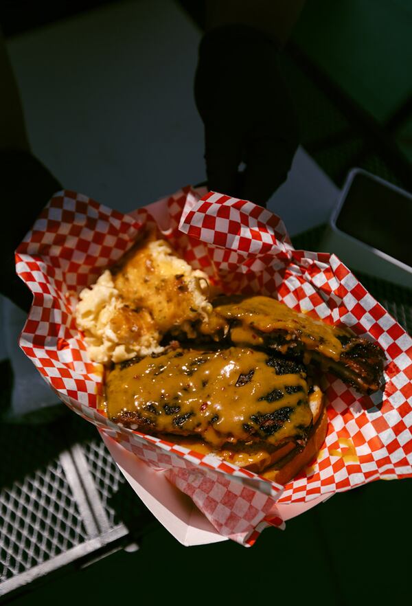 Grilled pork ribs served with sauce in a red-and-white checkered basket.