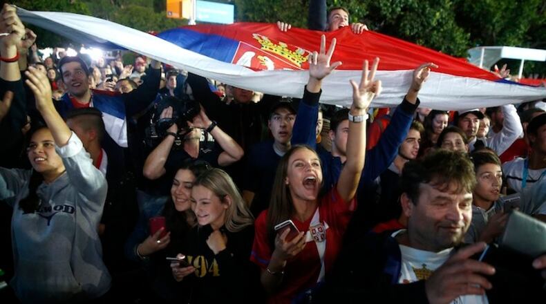 Fans cheer as Novak Djokovic of Serbia waves to spectators from a television studio after defeating Andy Murray of Britain in the men's singles final at the Australian Open tennis championships in Melbourne, Australia, Sunday, Jan. 31, 2016.(AP Photo/Rafiq Maqbool)