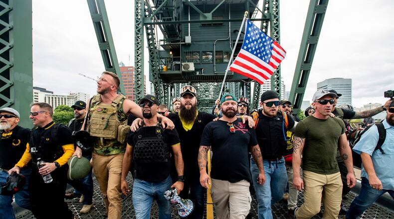 Proud Boys organizer Joseph Biggs, in green hat, was arrested in central Florida and faces charges of obstructing an official proceeding before Congress, entering a restricted area on the grounds of the U.S. Capitol and disorderly conduct. (AP Photo/Noah Berger, File)