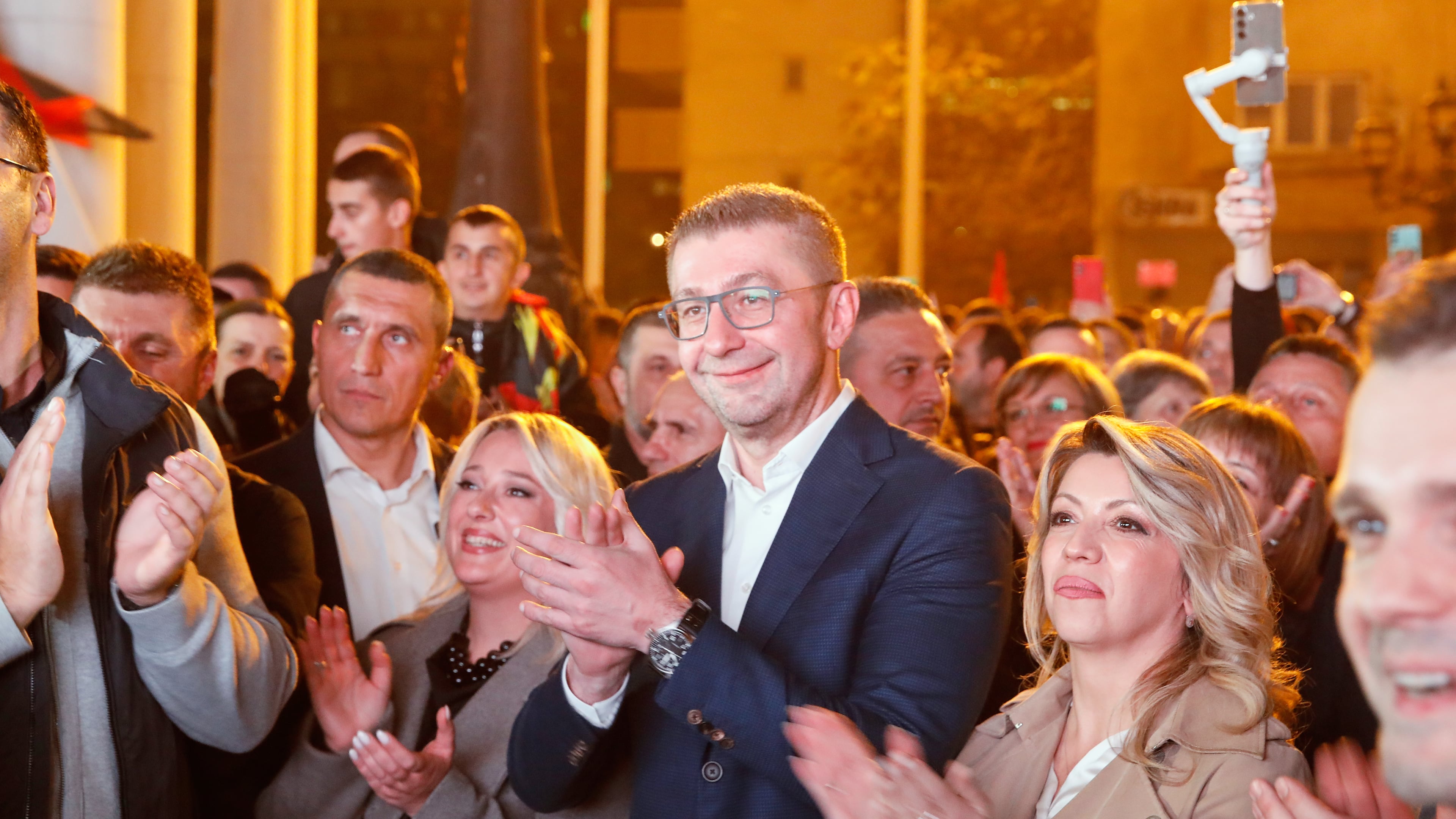 Hristijan Mickoski, center, the leader of the conservative VMRO-DPMNE party applauds in front of the party headquarters after announcing a "great" victory in the local elections, in Skopje, North Macedonia, on Sunday, Nov. 2, 2025. (AP Photo/Boris Grdanoski)