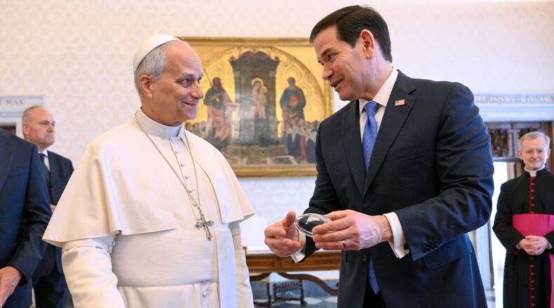 In this handout photo provided by Vatican Media Pope Leo XIV exchanges gifts with U.S. Secretary of State Marco Rubio, right, as they meet in the pope's private library at the Vatican, Thursday, May 7, 2026. (Vatican Media via AP)