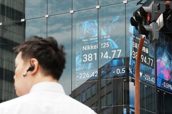 A person stands in front of an electronic stock board showing Japan's Nikkei index at a securities firm Thursday, June 12, 2025, in Tokyo. (AP Photo/Eugene Hoshiko)