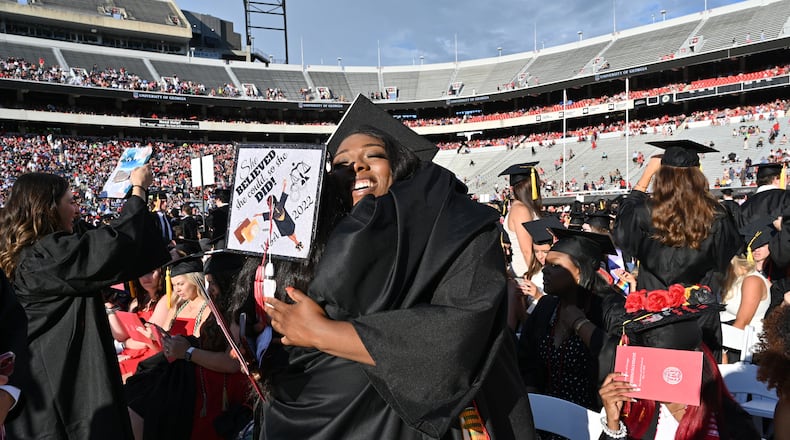 University of Georgia graduates Analla Reid (left) and Danielle Obiri hug before the 2022 Spring Undergraduate Commencement at Sanford Stadium in Athens on Friday, May 13, 2022. The school conferred more than 13,000 awards, certificates and degrees during a recent 12-month stretch. (Hyosub Shin / Hyosub.Shin@ajc.com)