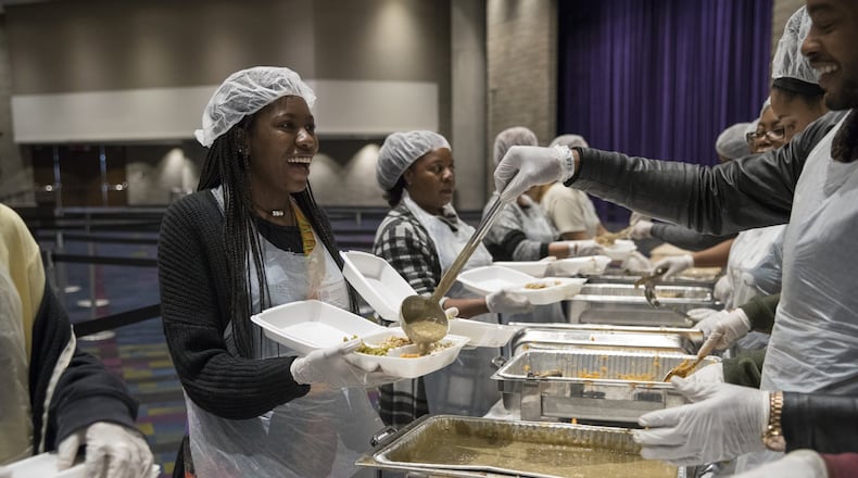 Karson Brown, left, laughs as she prepares a meal during the annual Hosea Helps Thanksgiving dinner at the Georgia World Congress Center in 2017. ALYSSA POINTER/ALYSSA.POINTER@AJC.COM