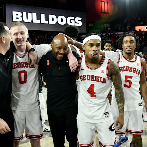 Georgia guard Blue Cain (front, second from left) and Georgia guard Marcus Millender (second from right) celebrate with coaching staff after Georgia beat Arkansas in an NCAA college basketball game at Stegeman Coliseum, Saturday, Jan. 17, 2026, in Athens. Georgia won 90-76 over Arkansas. (Hyosub Shin/AJC)