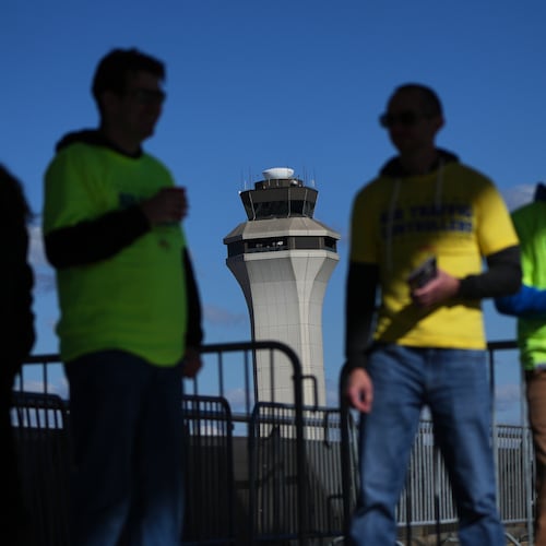 Air Traffic Controllers stand outside distributing leaflets explaining how the federal government shutdown is impacting air travel at Detroit Metropolitan Wayne County Airport Tuesday, Oct. 28, 2025, in Romulus, Mich. (AP Photo/Paul Sancya)
