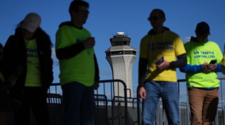 Air Traffic Controllers stand outside distributing leaflets explaining how the federal government shutdown is impacting air travel at Detroit Metropolitan Wayne County Airport Tuesday, Oct. 28, 2025, in Romulus, Mich. (AP Photo/Paul Sancya)
