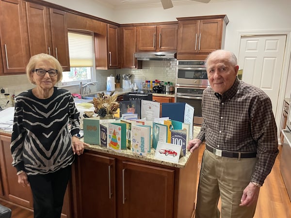 Hilbert and Betty Ann Margol in front of cards celebrating his 100th birthday. The couple has been married 75 years. (Bill Torpy/AJC)