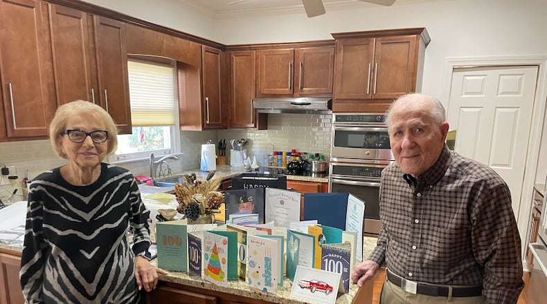 Hilbert and Betty Ann Margol in front of cards celebrating his 100th birthday. The couple has been married 75 years.