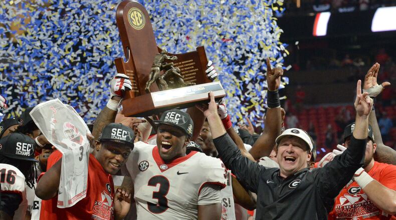 Georgia linebacker Roquan Smith (left), the game’s MVP,  coach Kirby Smart and other Bulldogs players celebrate after a 28-7 win over Auburn in the SEC championship game Saturday at Mercedes-Benz Stadium.