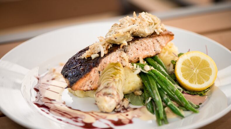 Sage Woodfire Tavern Salmon with jumbo lump blue crab, artichoke hearts, wild rice, haricot vert, and chardonnay caper beurre blanc. Photo credit- Mia Yakel.