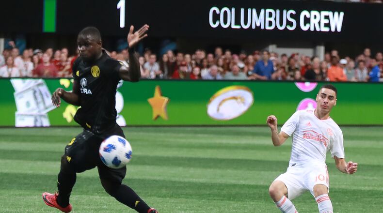 Atlanta United midfielder Miguel Almiron scores a goal past Columbus Crew defender Jonathan Mensah for a 3-1 victory during the second half in a MLS soccer match on Sunday, August 19, 2018, in Atlanta. Curtis Compton/ccompton@ajc.com