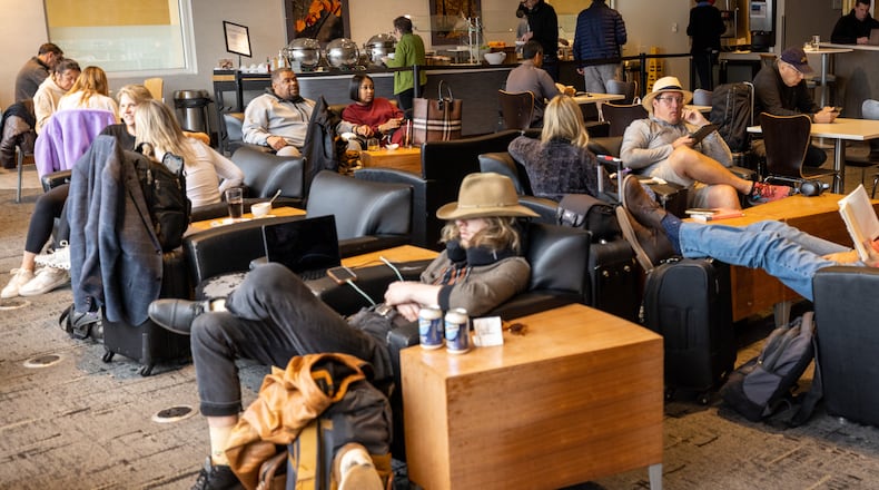 Travelers relax between flights at the Club At Atl airport Lounge Tuesday, Feb. 21. (Steve Schaefer/steve.schaefer@ajc.com)