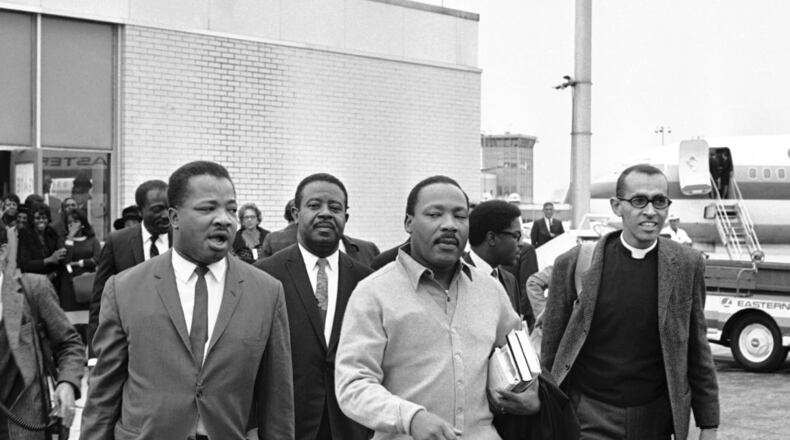 The Rev. Martin Luther King Jr. carries books as he heads toward the airplane that was to take him from Atlanta to Birmingham, Oct. 30, 1967, where he faced a five-day jail term for parading against court orders during 1963 civil rights demonstrations in Alabama. With King for the trip — and the jail term — were (from left) the Rev. A.D. King, Ralph Abernathy and Wyatt Tee Walker. AP Photo