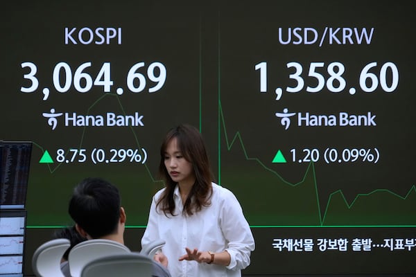 Currency traders work near a screen showing the Korea Composite Stock Price Index (KOSPI), left, and the foreign exchange rate between U.S. dollar and South Korean won at the foreign exchange dealing room of the KEB Hana Bank headquarters in Seoul, South Korea, Monday, June 30, 2025. (AP Photo/Ahn Young-joon)