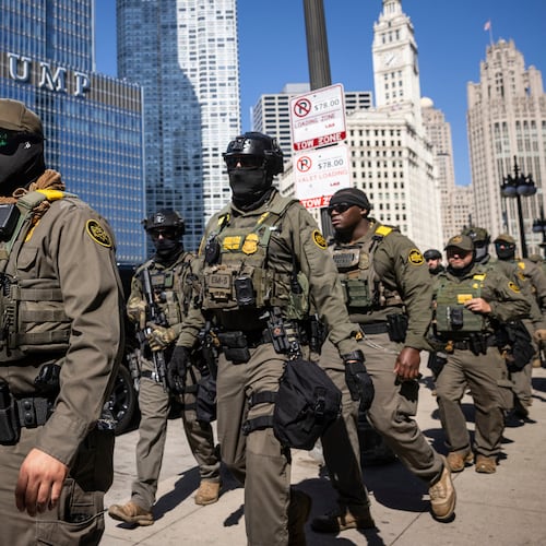 Federal agents from U.S. Immigration and Customs Enforcement and U.S. Customs and Border Protection walk along West Wacker Drive in the Loop, Sunday, Sept. 28, 2025, in Chicago. (Ashlee Rezin/Chicago Sun-Times via AP)