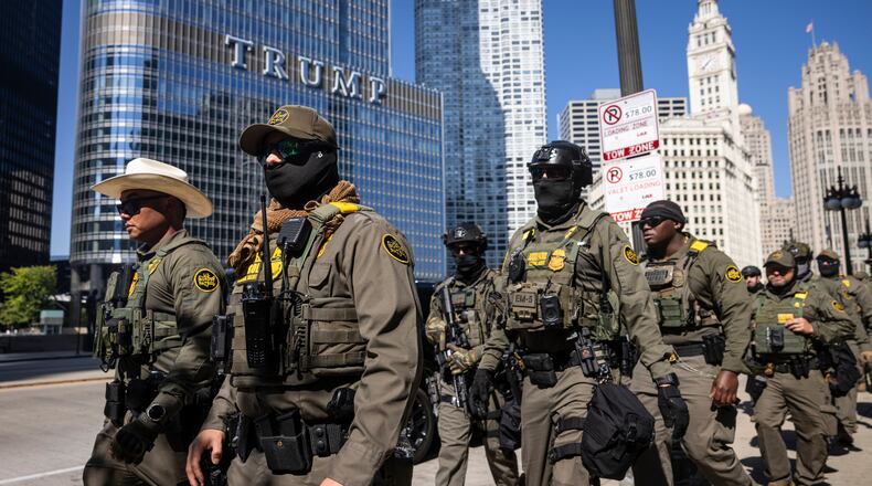 Federal agents from U.S. Immigration and Customs Enforcement and U.S. Customs and Border Protection walk along West Wacker Drive in the Loop, Sunday, Sept. 28, 2025, in Chicago. (Ashlee Rezin/Chicago Sun-Times via AP)