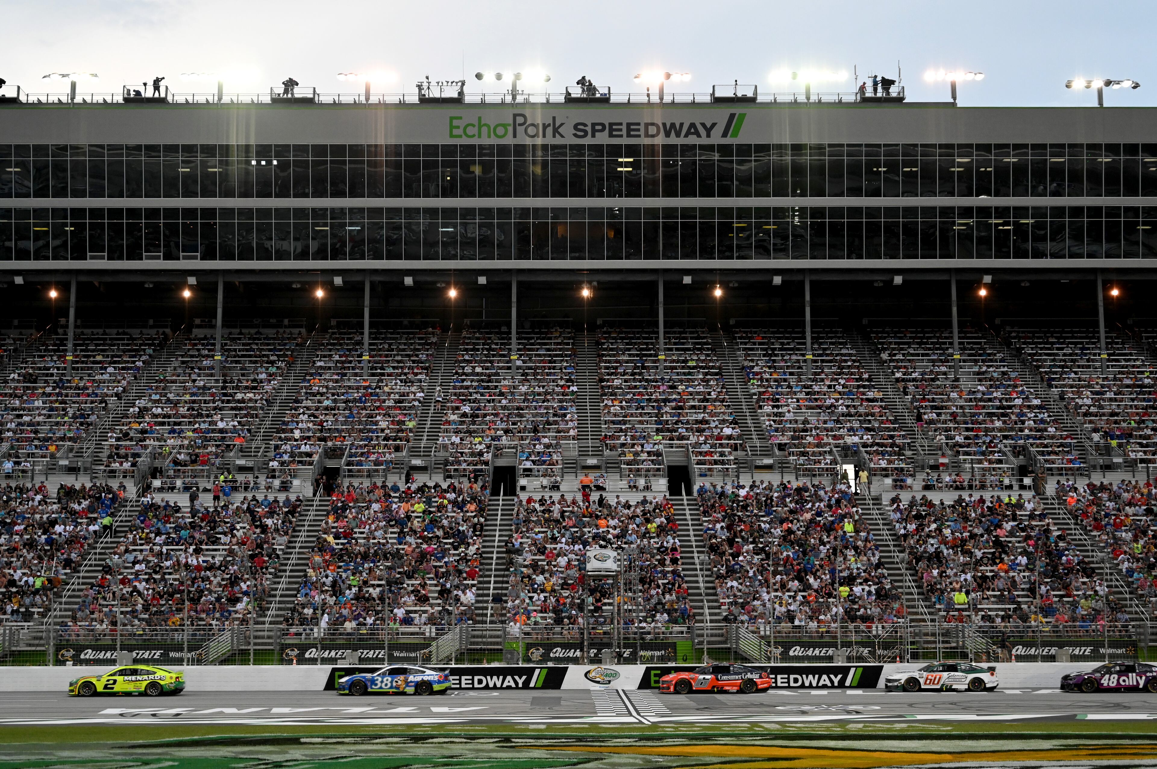 Drivers speed past the start line during Quaker State 400 NASCAR Cup Series race at EchoPark Speedway, Saturday, June 28, 2025, in Hampton. (Hyosub Shin / AJC)